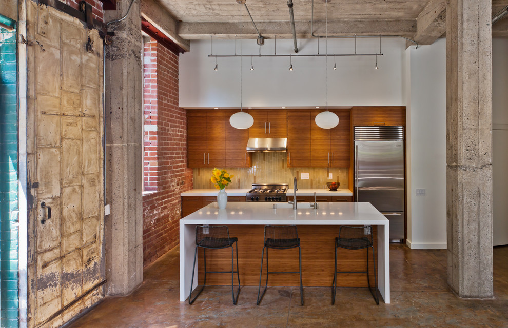 Industrial galley kitchen in San Francisco with an integrated sink, stainless steel appliances, flat-panel cabinets, medium wood cabinets and quartz benchtops.