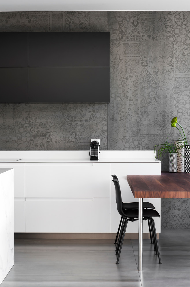 This is an example of a mid-sized modern l-shaped eat-in kitchen in Sydney with an integrated sink, dark wood cabinets, solid surface benchtops, grey splashback, cement tile splashback, ceramic floors and with island.