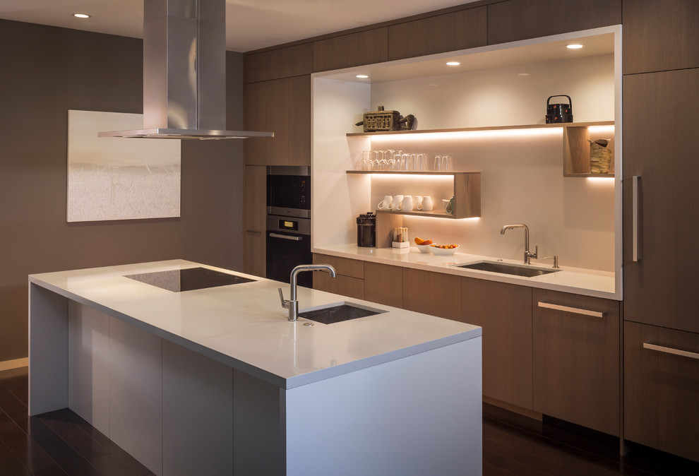 Inspiration for a mid-sized contemporary galley kitchen in San Francisco with an undermount sink, flat-panel cabinets, medium wood cabinets, quartz benchtops, white splashback, stainless steel appliances, with island, glass sheet splashback and dark hardwood floors.