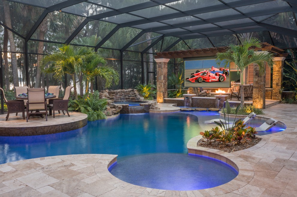 Mid-sized country backyard custom-shaped pool in Tampa with a water feature and natural stone pavers.