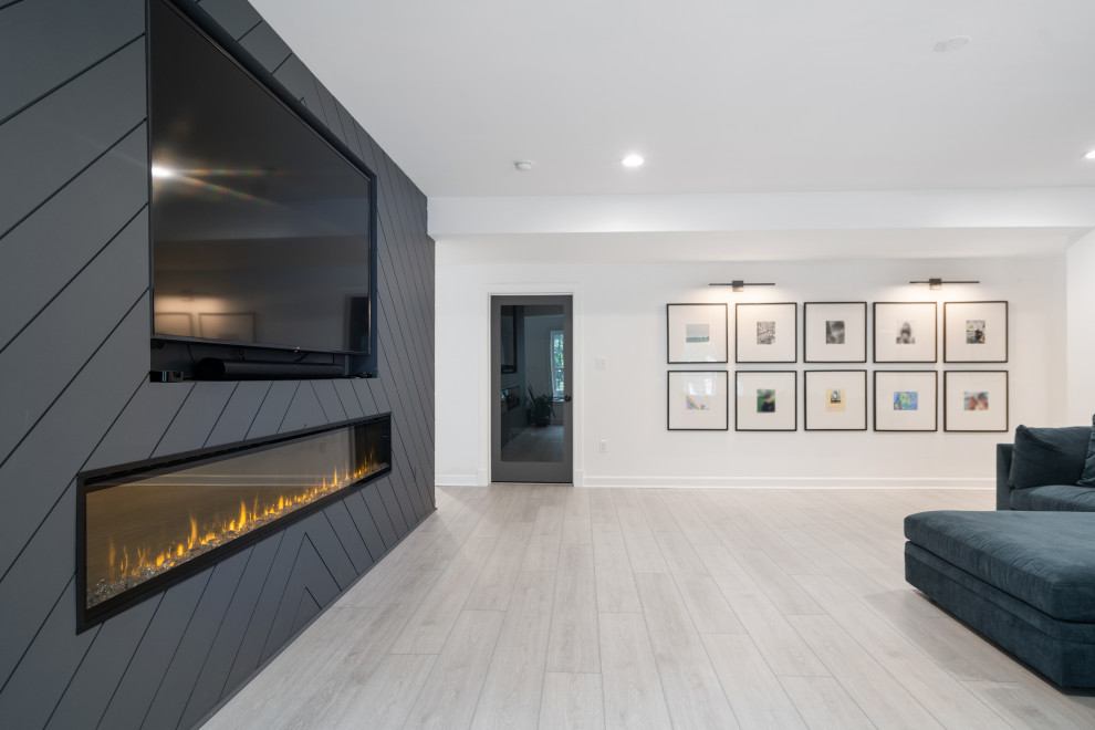 Modern inredning av ett mellanstort allrum med öppen planlösning, med vita väggar, vinylgolv, en inbyggd mediavägg och grått golv