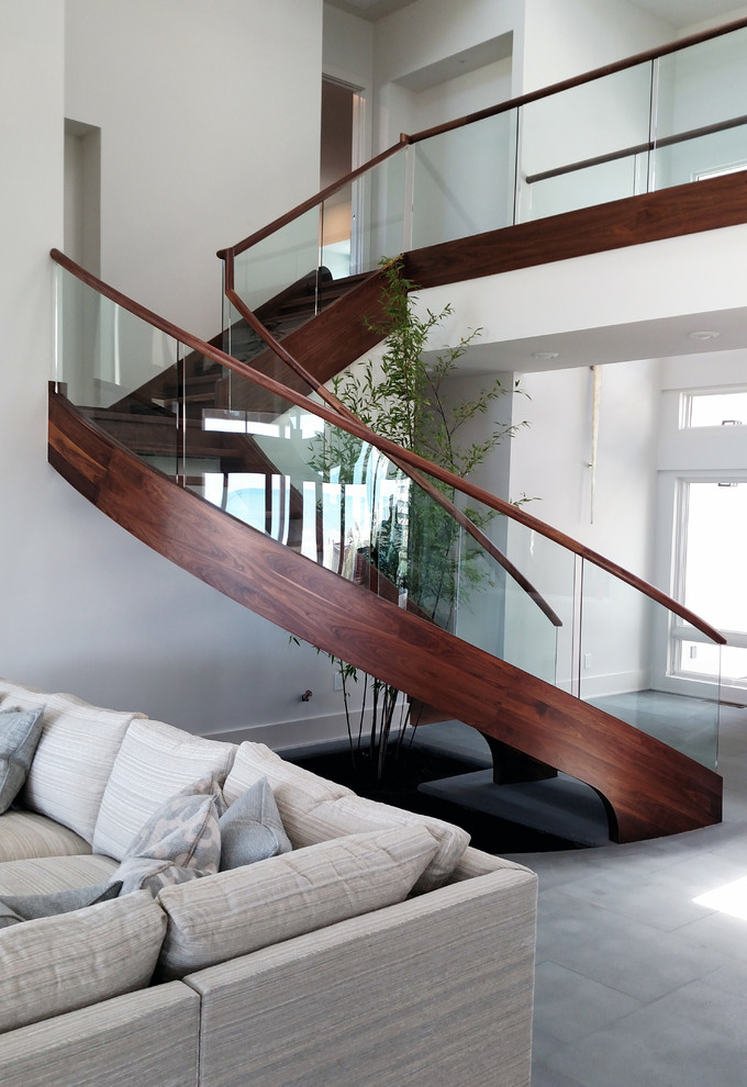 Large contemporary wood curved staircase in Charleston with open risers.