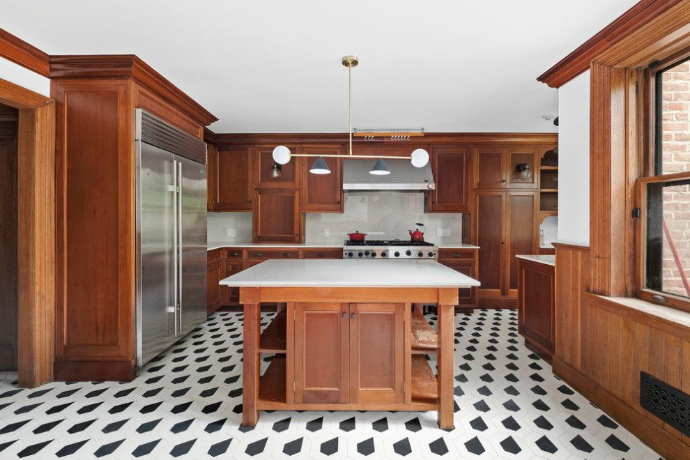 Eat-in kitchen - large transitional galley ceramic tile and multicolored floor eat-in kitchen idea in New York with a drop-in sink, recessed-panel cabinets, medium tone wood cabinets, quartz countertops, paneled appliances, an island and white countertops