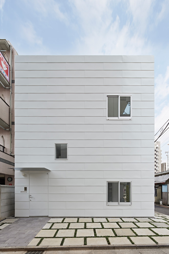 Contemporary two-storey white house exterior in Tokyo with wood siding and a flat roof.