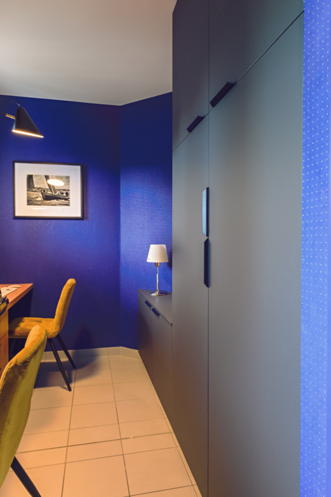 Foto de despacho contemporáneo de tamaño medio con paredes azules, suelo de baldosas de cerámica, escritorio empotrado, suelo gris y papel pintado