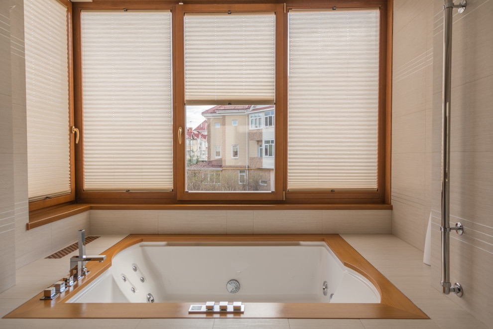 Idéer för att renovera ett litet funkis beige beige en-suite badrum, med vita skåp, ett badkar i en alkov, beige kakel, stenkakel, beige väggar, klinkergolv i porslin, marmorbänkskiva och beiget golv
