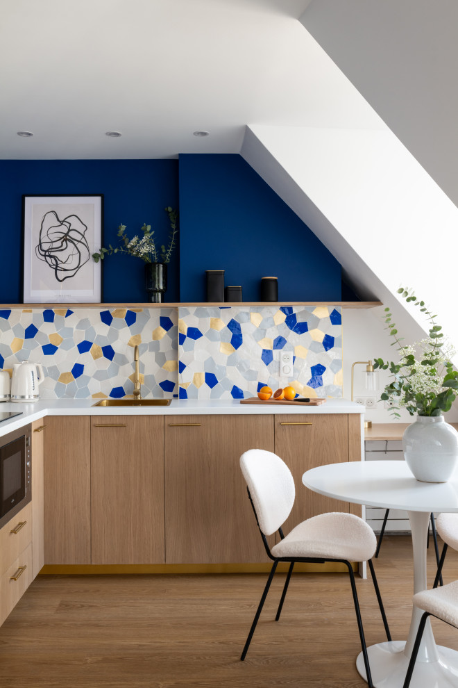 Offene, Mittelgroße Moderne Küche in L-Form mit Waschbecken, hellen Holzschränken, bunter Rückwand, Rückwand aus Mosaikfliesen, braunem Holzboden, braunem Boden und weißer Arbeitsplatte in Paris