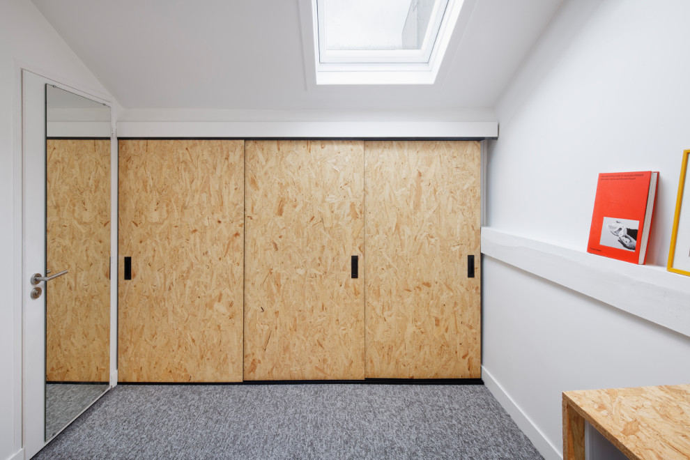 Cette image montre un placard dressing urbain en bois clair de taille moyenne et neutre avec moquette et un sol gris.