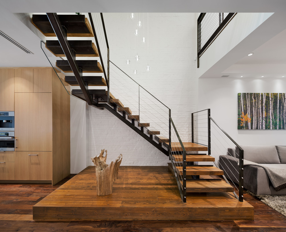 Photo of a large contemporary wood u-shaped staircase in New York with open risers.
