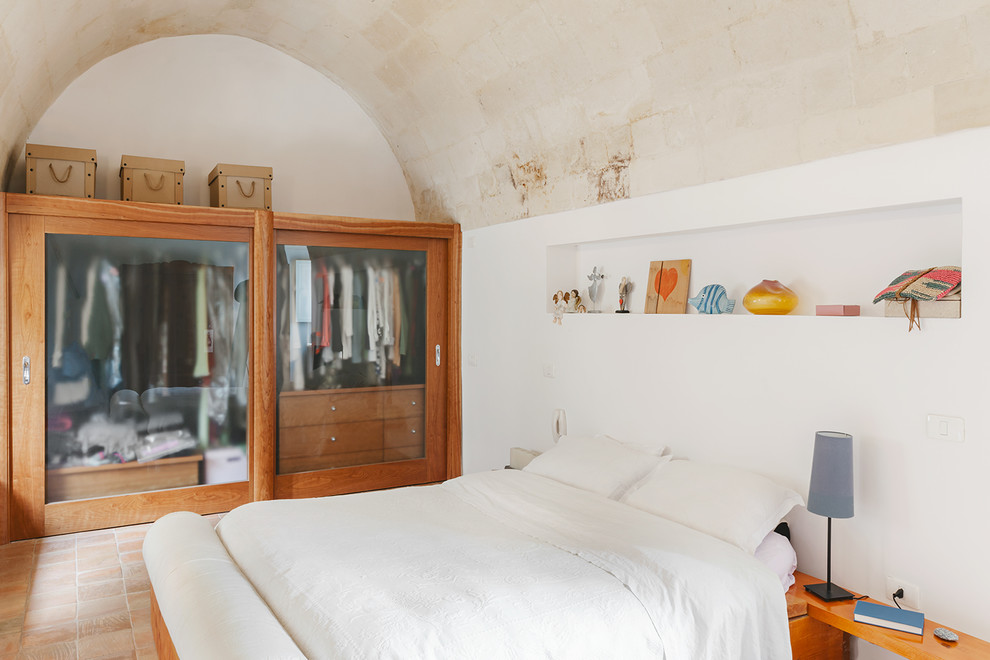 This is an example of a mediterranean master bedroom in Other with terra-cotta floors.