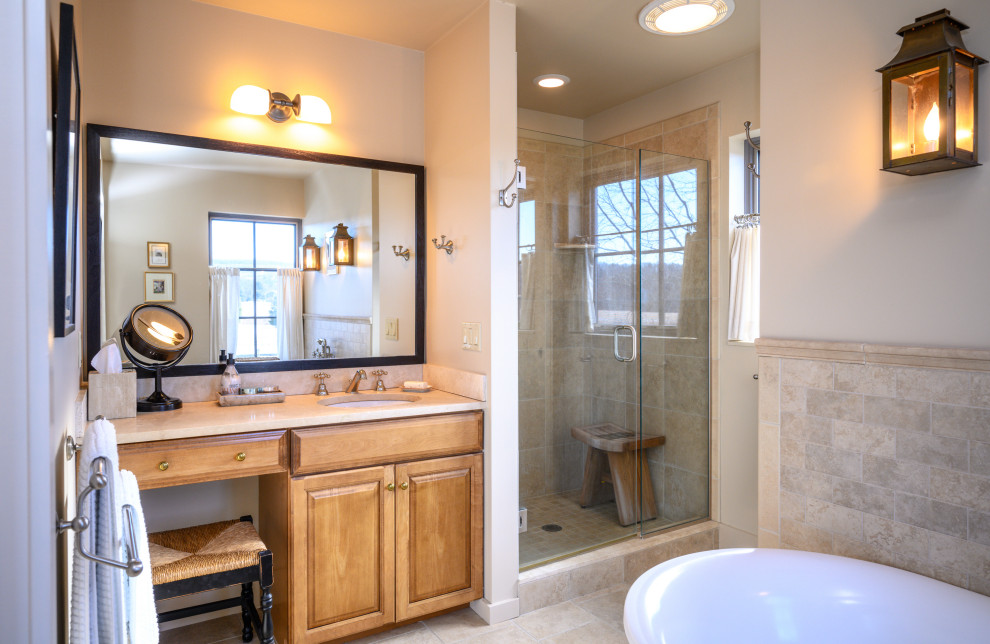 Example of a mid-sized transitional master beige tile and porcelain tile porcelain tile, beige floor and single-sink freestanding bathtub design with medium tone wood cabinets, a two-piece toilet, beige walls, an undermount sink, granite countertops, a hinged shower door, beige countertops and a built-in vanity