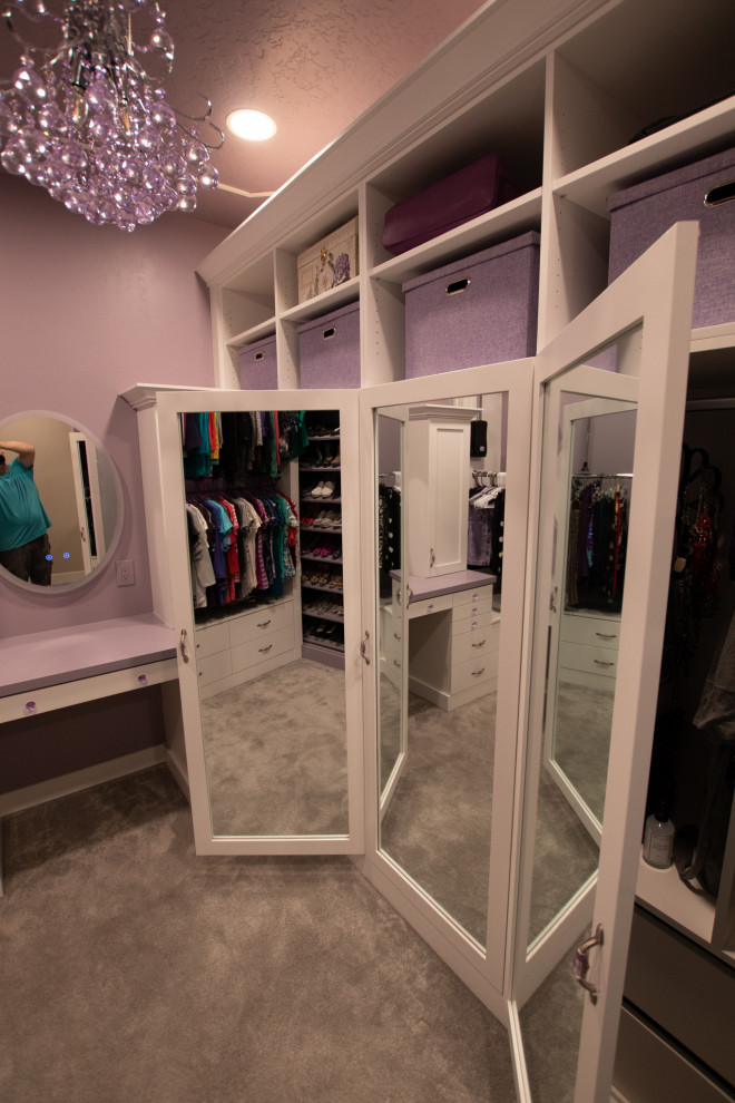 Inredning av ett modernt stort walk-in-closet för kvinnor, med släta luckor, vita skåp, heltäckningsmatta och lila golv