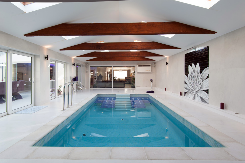 Inspiration for a large contemporary indoor rectangular pool in London with tile.