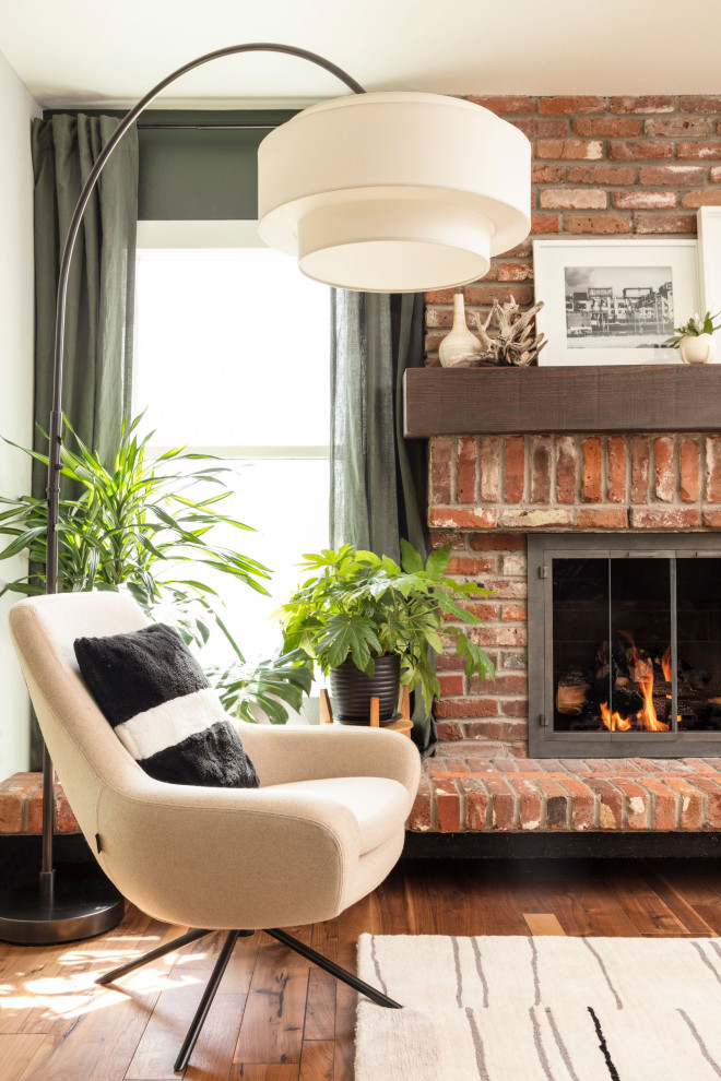 Large midcentury open concept living room in Denver with green walls, medium hardwood floors, a standard fireplace, a brick fireplace surround, brown floor, recessed and wallpaper.