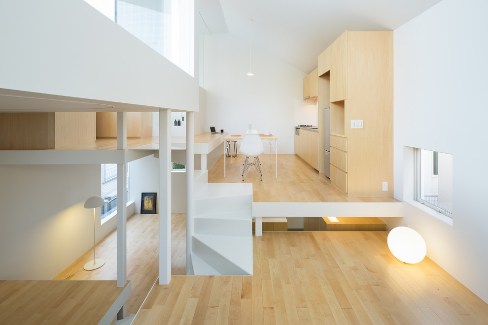 This is an example of a small modern open plan dining in Tokyo with white walls, light hardwood floors and beige floor.