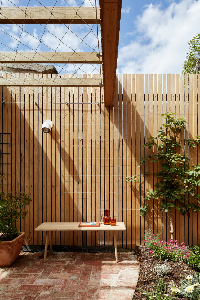 Ispirazione per un piccolo patio o portico design in cortile con pavimentazioni in mattoni e una pergola