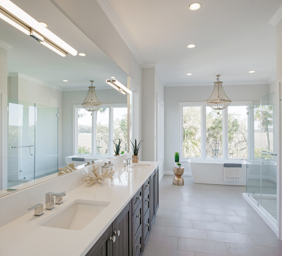 Inspiration for a large transitional master bathroom in Atlanta with shaker cabinets, medium wood cabinets, a freestanding tub, a double shower, a two-piece toilet, white tile, pebble tile, white walls, porcelain floors, an undermount sink and engineered quartz benchtops.