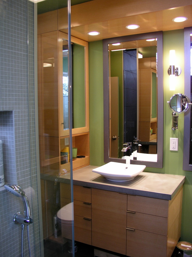 Small contemporary master bathroom in Calgary with a vessel sink, flat-panel cabinets, light wood cabinets, concrete benchtops, a corner shower, a two-piece toilet, gray tile, ceramic tile, green walls and ceramic floors.