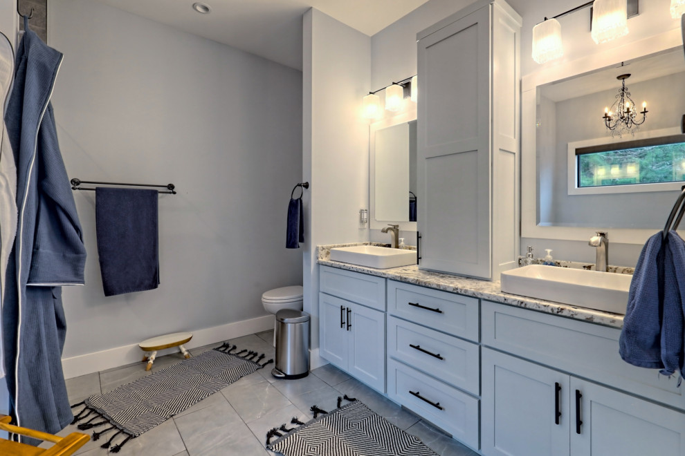 Exempel på ett stort klassiskt flerfärgad flerfärgat en-suite badrum, med skåp i shakerstil, vita skåp, ett fristående badkar, en toalettstol med separat cisternkåpa, grå väggar, klinkergolv i keramik, ett fristående handfat, granitbänkskiva, grått golv, dusch med gångjärnsdörr och en dusch i en alkov