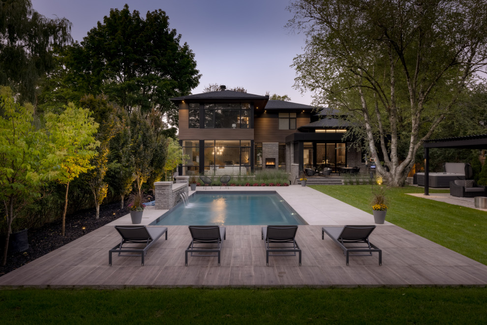 Стильный дизайн: прямоугольный бассейн на заднем дворе в стиле модернизм с покрытием из плитки - последний тренд