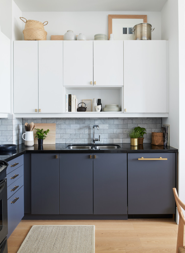 Inspiration for a small contemporary l-shaped eat-in kitchen in Toronto with an undermount sink, flat-panel cabinets, grey cabinets, granite benchtops, grey splashback, stone tile splashback, stainless steel appliances, light hardwood floors, beige floor and black benchtop.