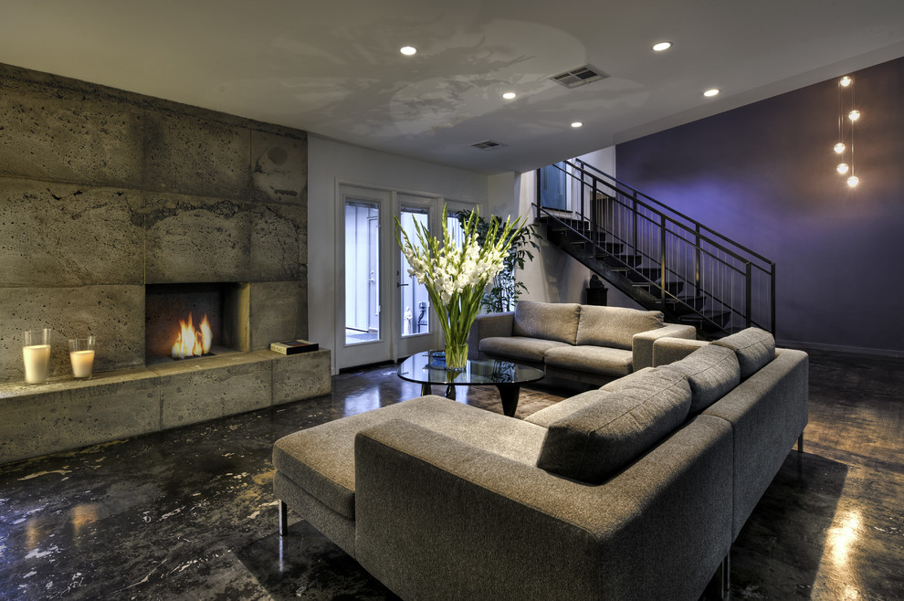 Design ideas for a contemporary living room in Houston with purple walls, a standard fireplace, concrete floors and a concrete fireplace surround.