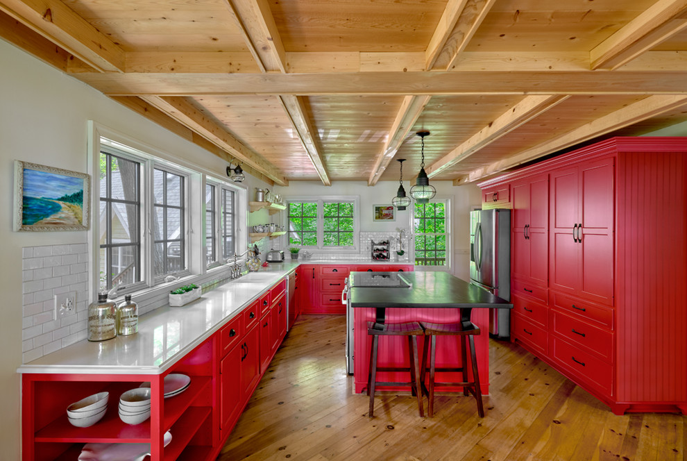This is an example of a mid-sized beach style kitchen in Chicago with recessed-panel cabinets, red cabinets, quartz benchtops, white splashback, stainless steel appliances, with island, white benchtop, subway tile splashback and medium hardwood floors.