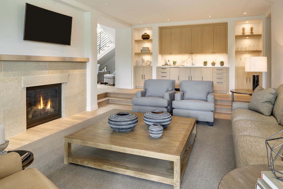 Inspiration for a contemporary enclosed family room in Minneapolis with white walls, light hardwood floors, a standard fireplace, a stone fireplace surround, a wall-mounted tv and a home bar.