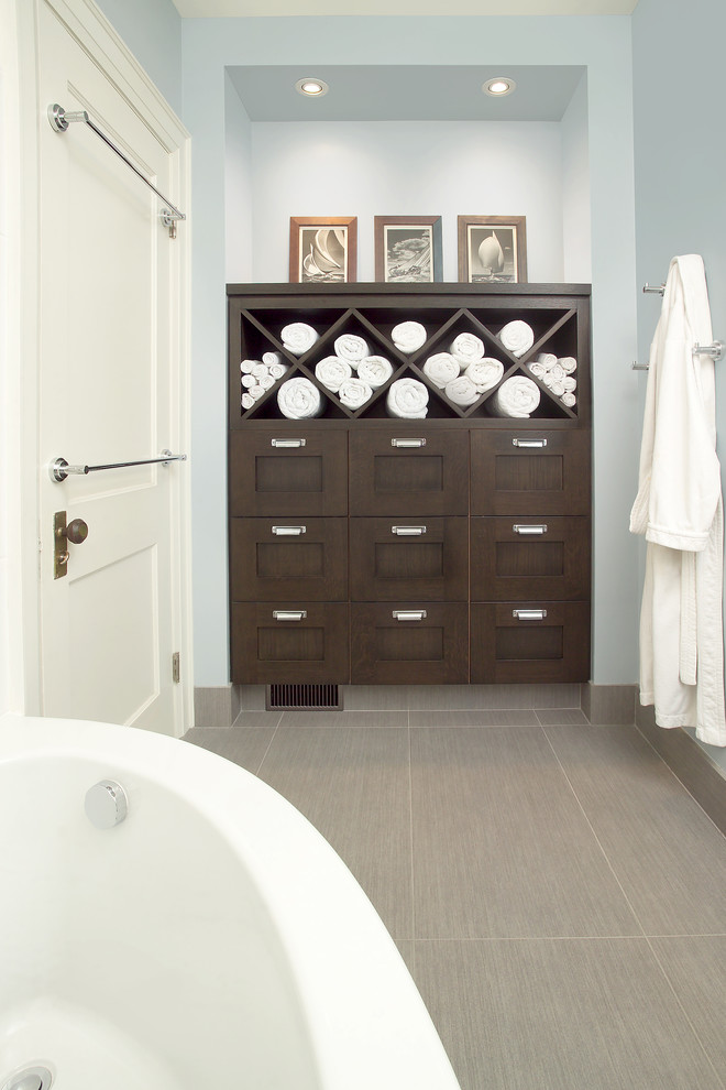 This is an example of a transitional bathroom in Toronto with a corner tub, dark wood cabinets, wood benchtops, gray tile, porcelain tile, porcelain floors and shaker cabinets.