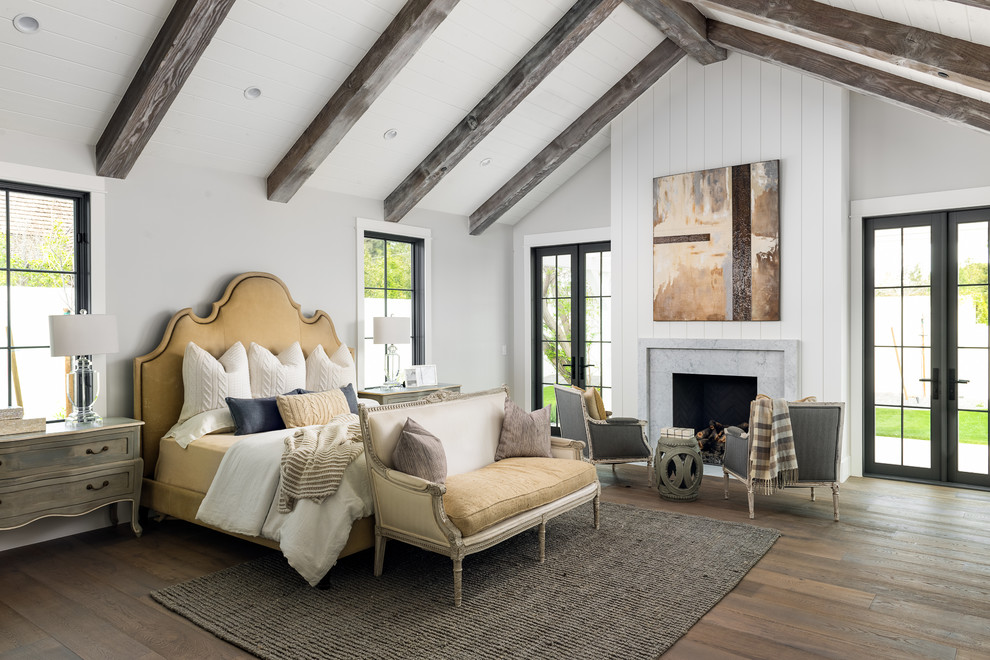 Inspiration for a bedroom in Phoenix with grey walls, dark hardwood floors, a standard fireplace and brown floor.