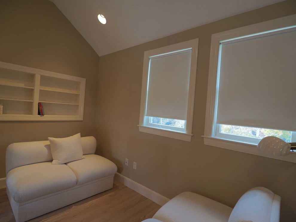 Design ideas for a mid-sized transitional master bedroom in Boston with beige walls and light hardwood floors.