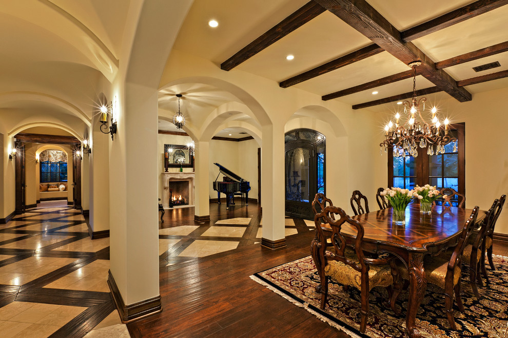 Photo of a large mediterranean dining room in Phoenix with beige walls, dark hardwood floors and brown floor.