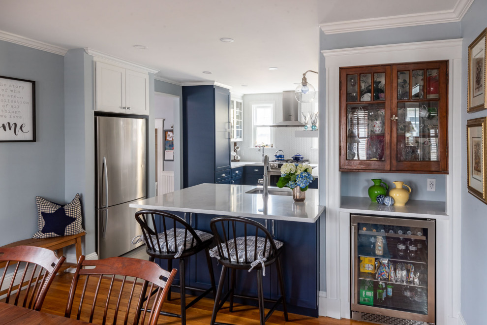 Eat-in kitchen - mid-sized transitional u-shaped porcelain tile and gray floor eat-in kitchen idea in Boston with an undermount sink, shaker cabinets, blue cabinets, quartz countertops, white backsplash, subway tile backsplash, stainless steel appliances, a peninsula and white countertops