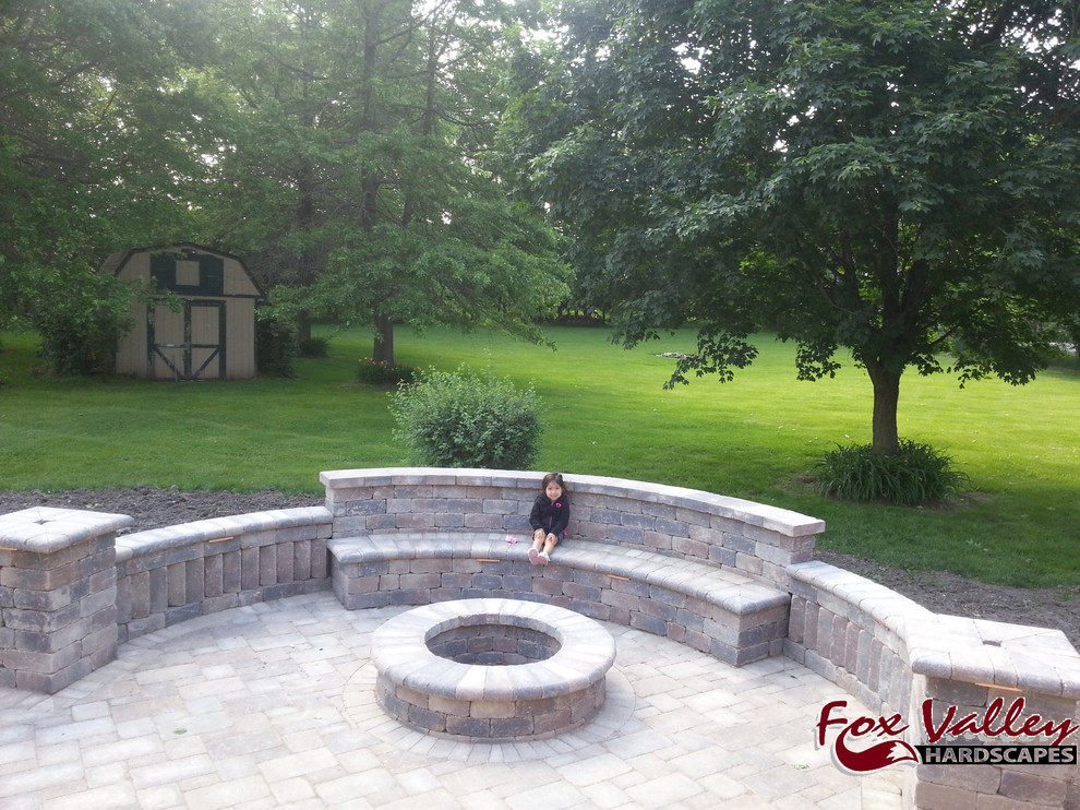 Photo of a large country backyard full sun garden in Chicago with a retaining wall and brick pavers.