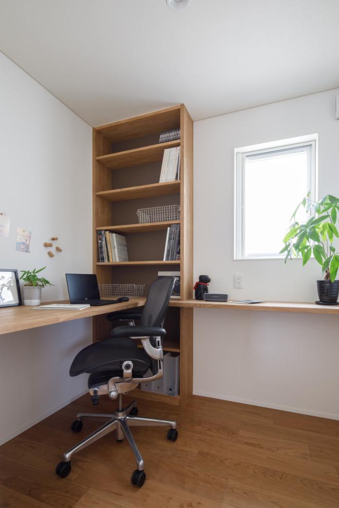 Nordisches Arbeitszimmer mit Arbeitsplatz, weißer Wandfarbe, Sperrholzboden, Einbau-Schreibtisch, Tapetendecke und Tapetenwänden in Sonstige