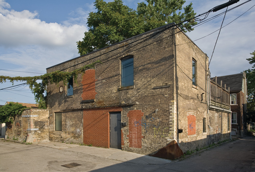 Design ideas for an industrial brick exterior in Toronto with a flat roof.