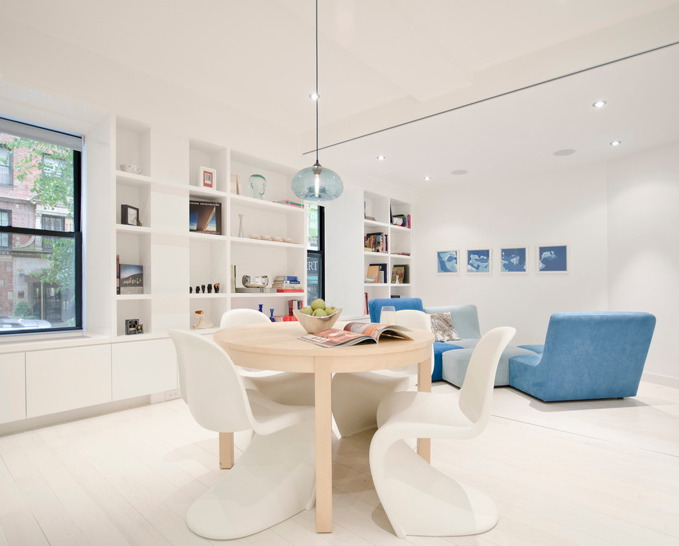 Inspiration for a modern dining room in New York with white walls, light hardwood floors and white floor.