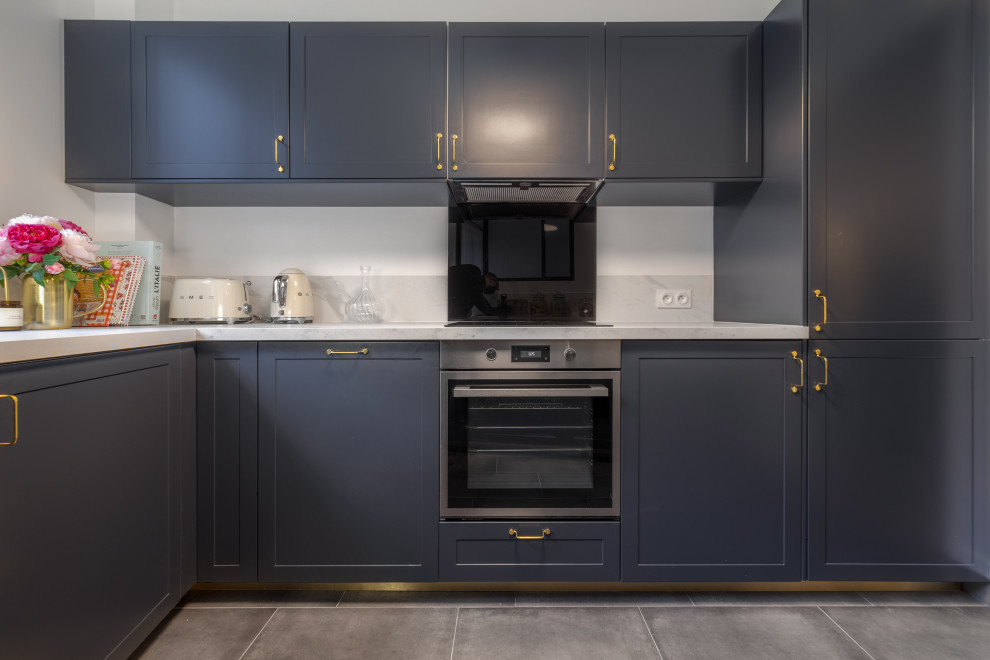 Photo of a medium sized traditional u-shaped enclosed kitchen in Paris with a single-bowl sink, recessed-panel cabinets, black cabinets, laminate countertops, white splashback, ceramic flooring, grey floors and white worktops.