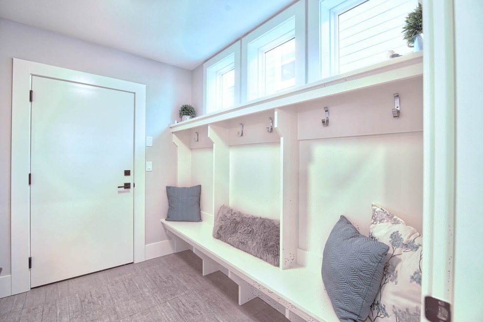 Photo of a large modern mudroom in Vancouver with white walls and ceramic floors.