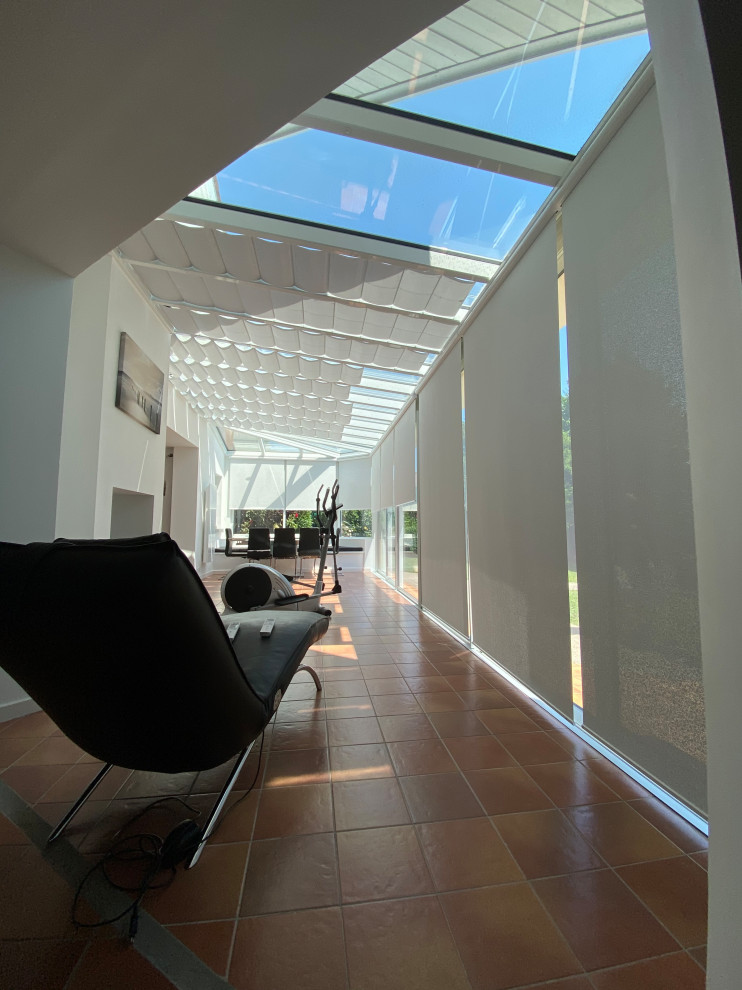 Exemple d'une grande véranda moderne avec un plafond en verre.