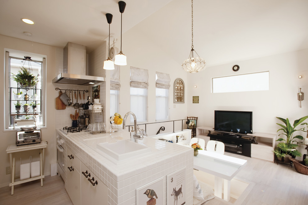 Inspiration for a country single-wall open plan kitchen in Tokyo Suburbs with painted wood floors, white floor, a drop-in sink, flat-panel cabinets, white cabinets, tile benchtops, white splashback, stainless steel appliances and a peninsula.
