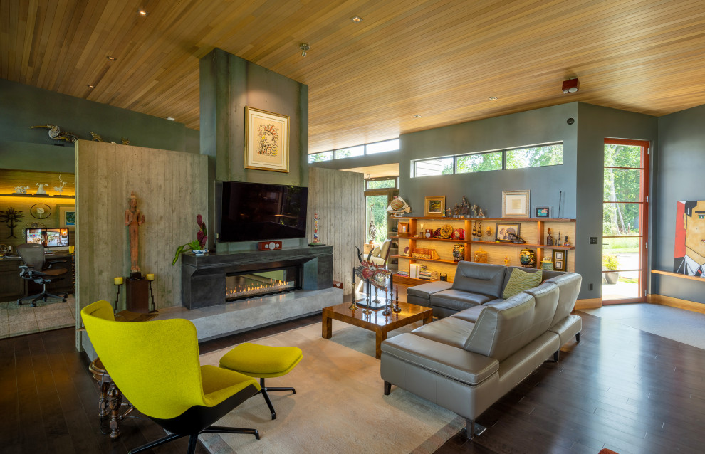 Design ideas for a mid-sized contemporary open concept living room in Seattle with grey walls, dark hardwood floors, a two-sided fireplace, a concrete fireplace surround, a wall-mounted tv, brown floor, wood and decorative wall panelling.