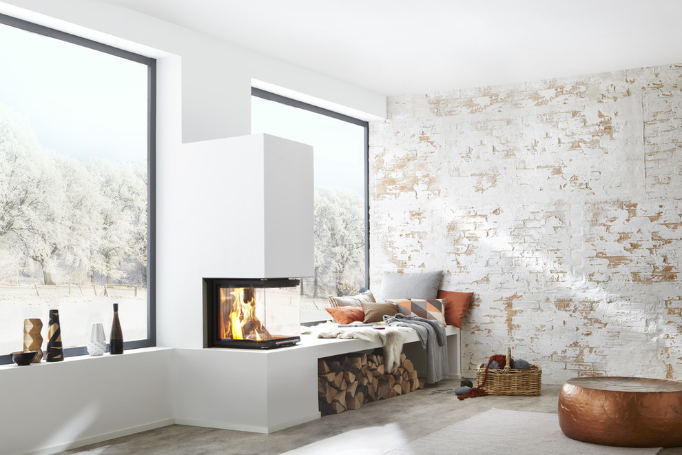 Small industrial formal open concept living room in Cologne with a two-sided fireplace, white walls, concrete floors and a plaster fireplace surround.