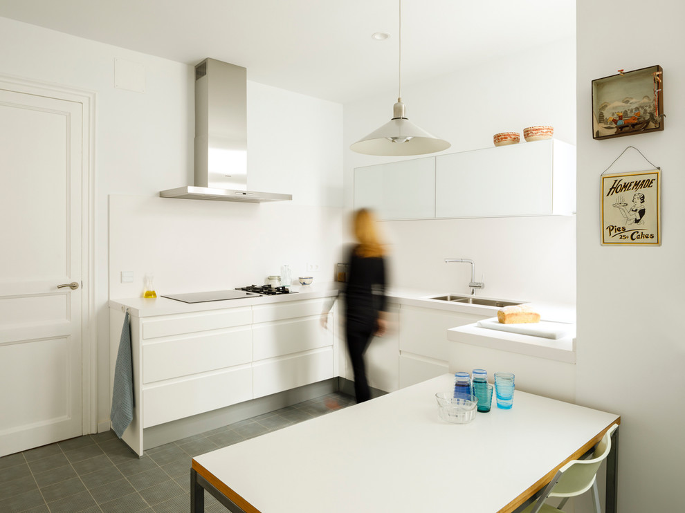 Photo of a contemporary u-shaped eat-in kitchen in Barcelona with recessed-panel cabinets, white cabinets, marble benchtops, porcelain floors, grey floor and white benchtop.