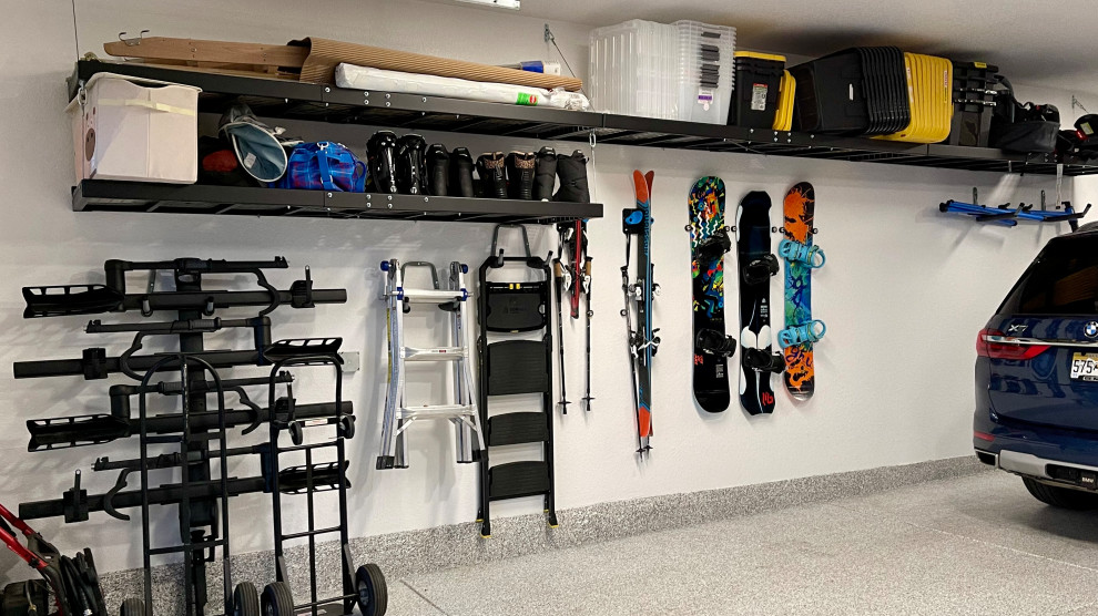 Example of a large minimalist attached three-car garage design in Denver