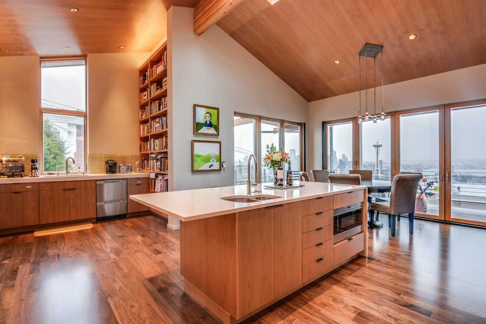 Example of a mid-sized minimalist medium tone wood floor eat-in kitchen design in Seattle with a double-bowl sink, flat-panel cabinets, medium tone wood cabinets, beige backsplash, ceramic backsplash, stainless steel appliances and an island