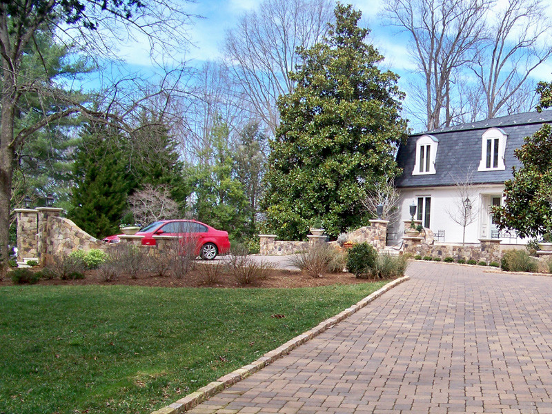 This is an example of a traditional front yard driveway in Other with concrete pavers.
