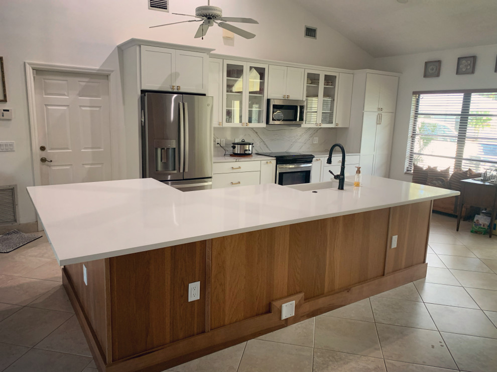 Eat-in kitchen - transitional eat-in kitchen idea with a farmhouse sink, shaker cabinets, white cabinets, quartz countertops, white backsplash, quartz backsplash, stainless steel appliances, an island and white countertops