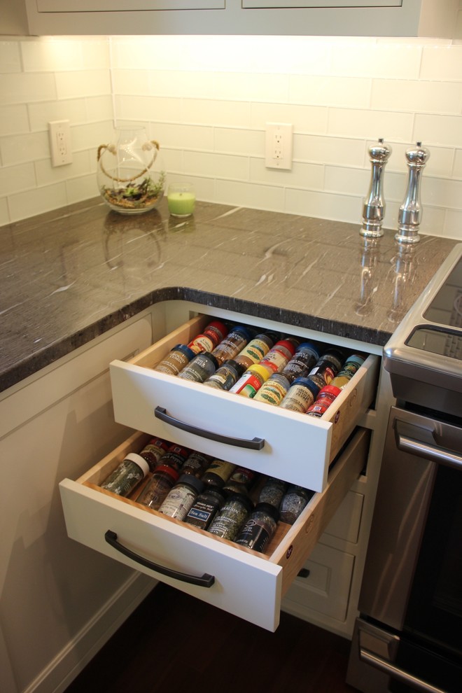 Inspiration for a mid-sized transitional l-shaped dark wood floor eat-in kitchen remodel with a double-bowl sink, shaker cabinets, white cabinets, granite countertops, white backsplash, glass tile backsplash, stainless steel appliances and an island