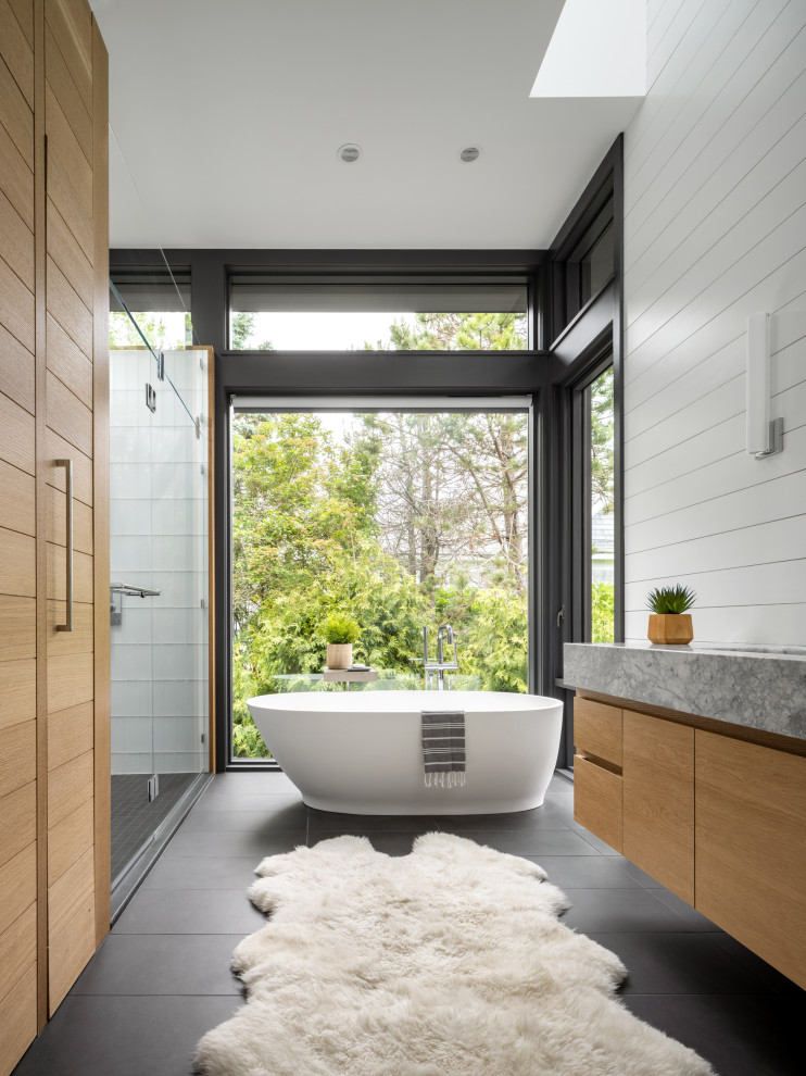 Beach style master bathroom in Portland Maine with a double vanity, a floating vanity, grey cabinets, a freestanding tub, a curbless shower, white walls, marble benchtops and an open shower.
